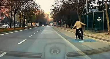 Eli cebinde bisikletle giderken araba altında kalmaktan son anda kurtuldu